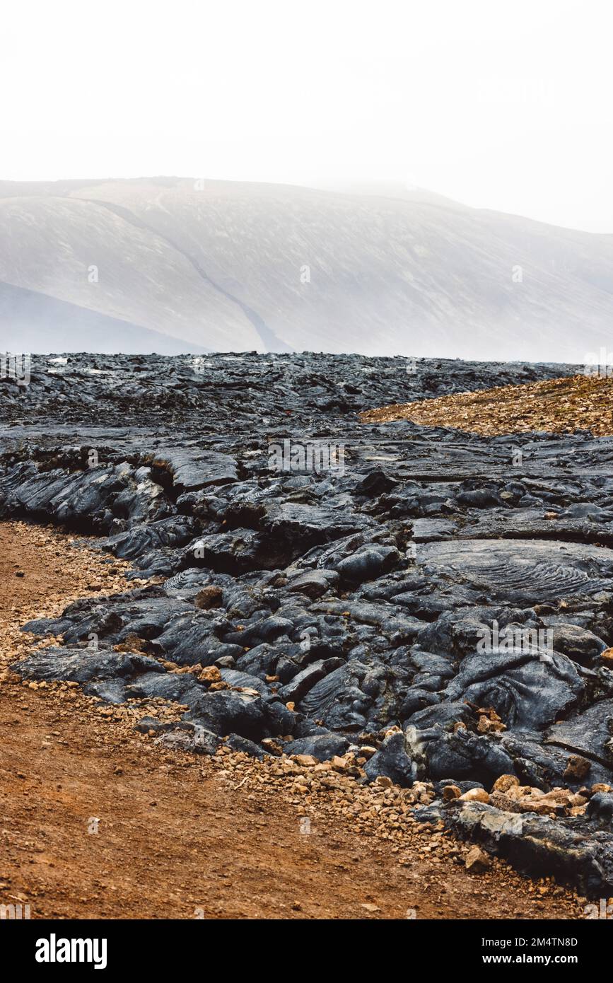 Vertikales Foto von os gekühlte Lava, die schwarze vulkanische Felsen an der Oberfläche bildet - Vulkan Geldingadalir Stockfoto