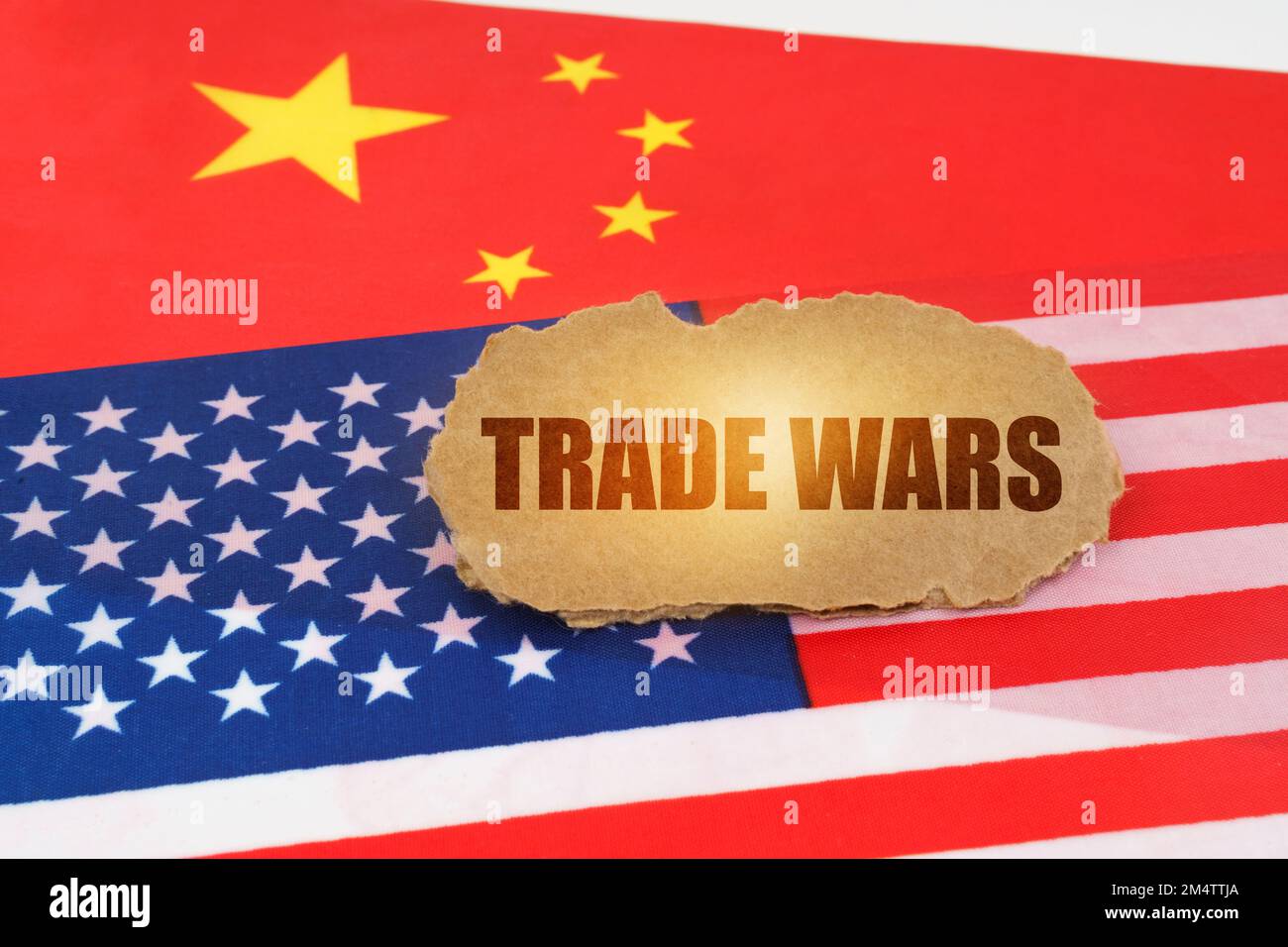 Politisches Konzept. Auf den Flaggen der USA und Chinas liegt ein Pappschild mit der Inschrift "Handelskriege" Stockfoto