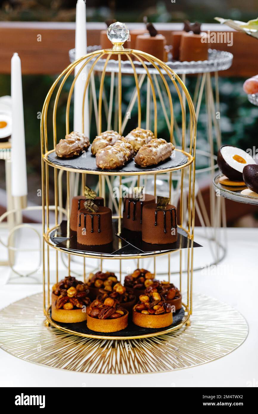 Viele Kuchen stehen unter dem Schokoriegel. Süßer Tisch. Banketttisch. Festtagsessen und ein süßer festlicher Tisch Stockfoto