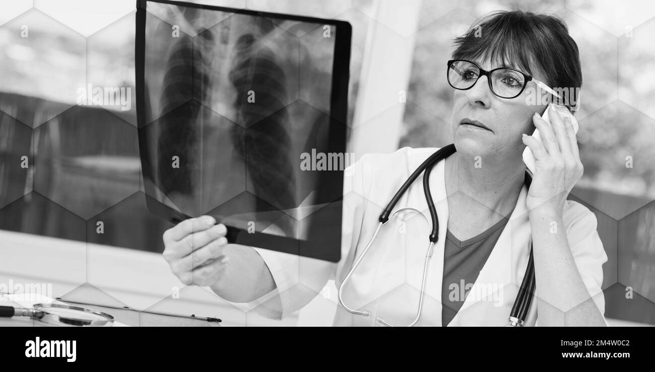 Ärztin untersucht Röntgenbericht in der Praxis, geometrisches Muster Stockfoto
