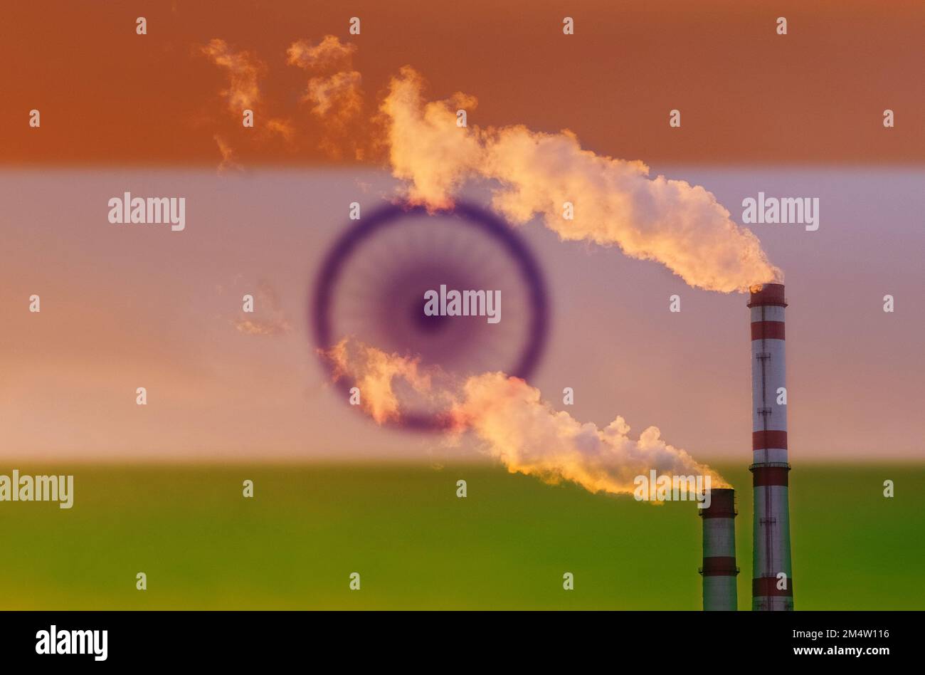 Ökologisches Konzept. Vor dem Hintergrund der indischen Flagge tritt Rauch aus den Schornsteinen eines Industrieunternehmens aus, der die Luft verschmutzt. Stockfoto