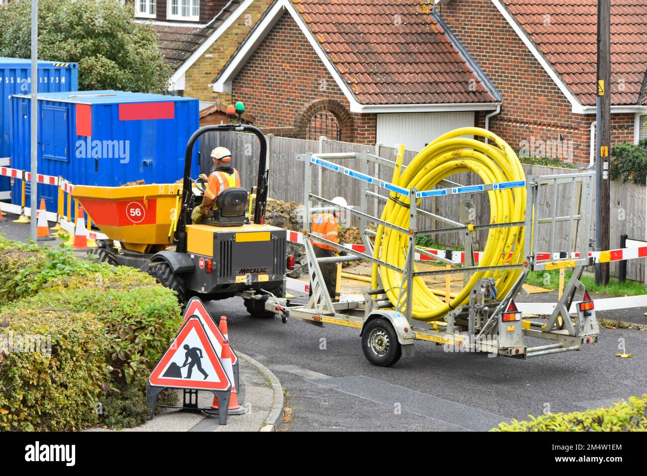 Gashauptunternehmer, der mit einem Kipplaster fährt und einen Anhänger schleppt, der mit einem großen gelben Kunststoffrohr beladen ist, um es in das alte Stahlrohr England UK einzusetzen Stockfoto