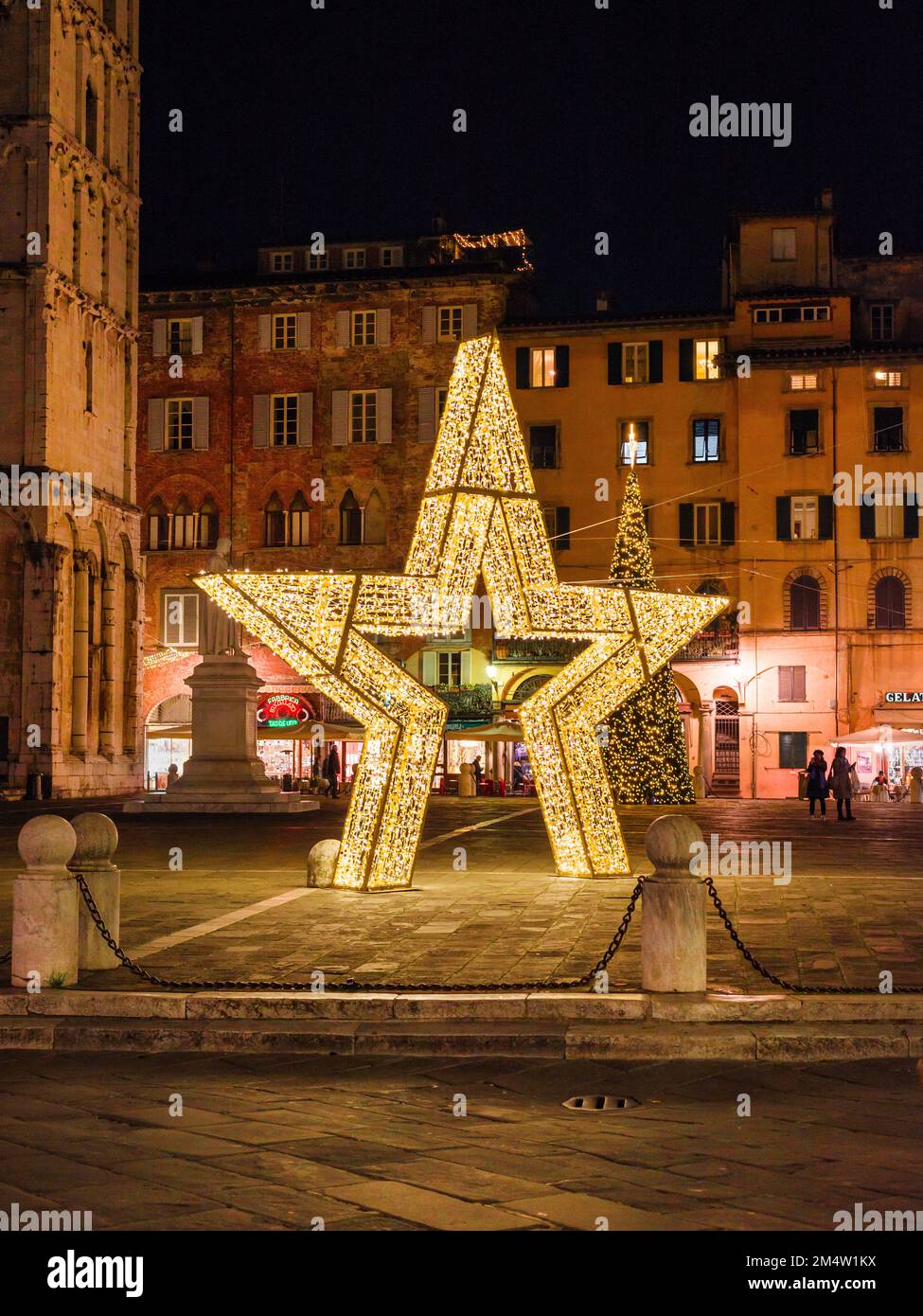 Weihnachten in Lucca. Ein riesiger Weihnachtsstern und Baum auf dem wunderschönen St. Michael Square Stockfoto