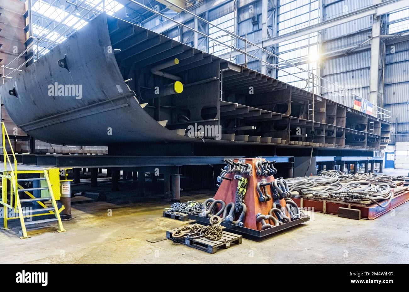 23. Dezember 2022, Schleswig-Holstein, Flensburg: Ein Rumpfsegment eines LNG-Bunkerschiffs liegt in einer Werft der Flensburger Schiffbau Gesellschaft (FSG). Heute übergab Bundeswirtschaftsminister Habeck der nordischen Schifffahrtsgesellschaft drei Bundesfinanzierungen für den Bau solcher Schiffe. In der Flensburger Schiffbau-Gesellschaft (FSG) sollen drei so genannte Bunkerschiffe für Flüssigerdgas (LNG) gebaut werden. Bundeswirtschaftsminister Habeck (Grüne) übergab den Reedereien am Freitag drei Finanzierungsbescheide im Gesamtwert von 62 Millionen Euro. Foto: Markus Scholz/dpa Stockfoto