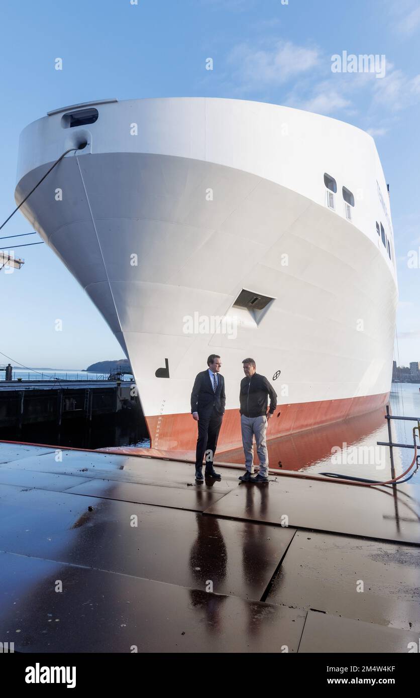 23. Dezember 2022, Schleswig-Holstein, Flensburg: Robert Habeck (Greens,r), Bundeswirtschaftsminister, steht neben Philipp Maracke, Geschäftsführer der FSG-Nobiskrug Holding, auf dem Werftgelände vor dem Bau eines neuen Schiffes. In der Flensburger Schiffbau-Gesellschaft (FSG) sollen drei so genannte Bunkerschiffe für Flüssigerdgas (LNG) gebaut werden. Am Freitag übergab Bundeswirtschaftsminister Robert Habeck (Grüne) den Reedereien drei Finanzierungsbescheide über insgesamt 62 Millionen Euro. Foto: Markus Scholz/dpa Stockfoto