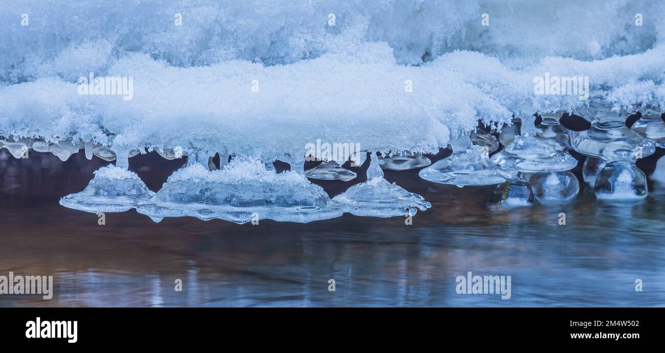 Eiszapfen im Winter, kaltes Wetter mit Eiszapfen über dem Fluss Stockfoto