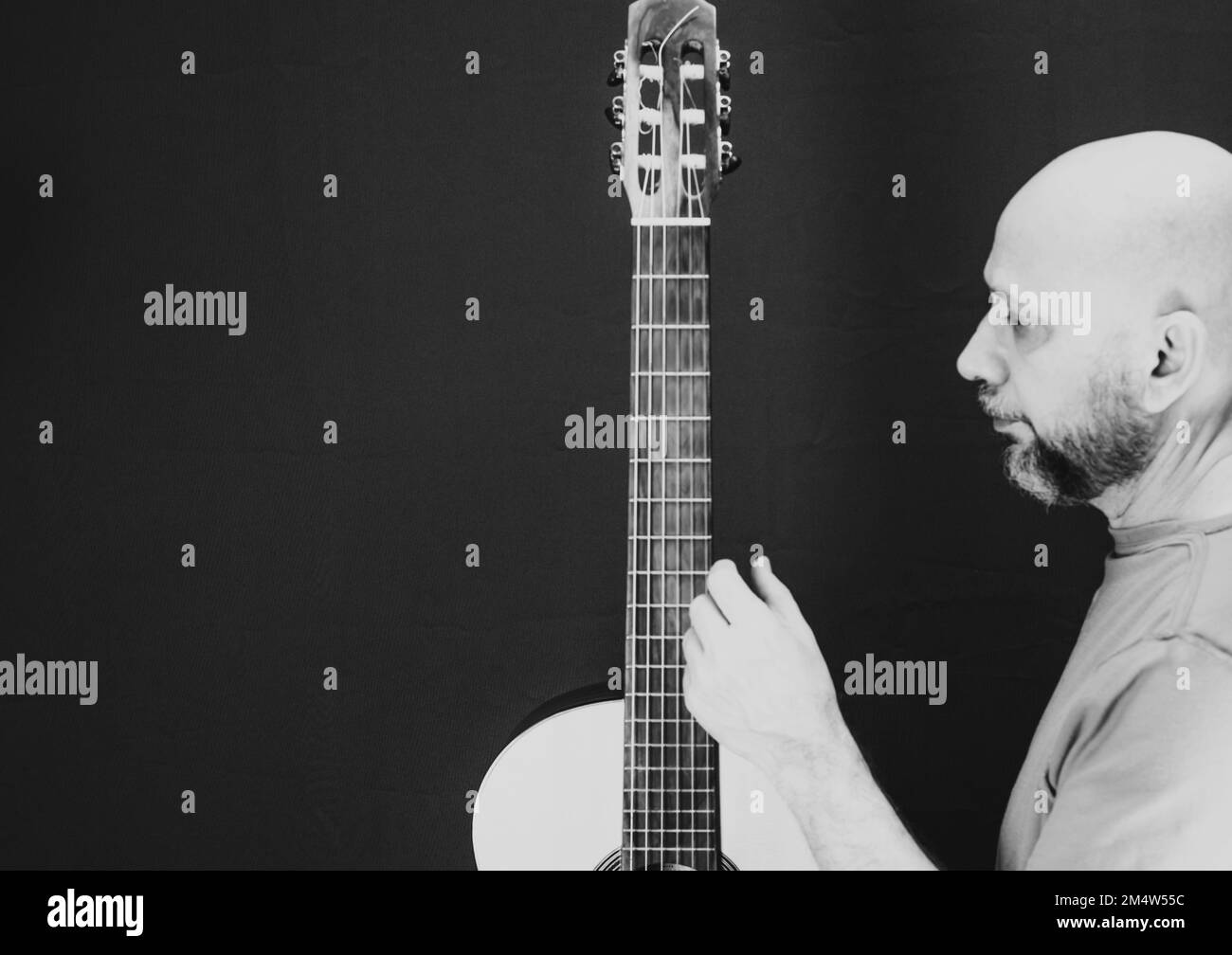 Eine Graustufenaufnahme eines charismatischen, kaukasischen männlichen Gitarrist Stockfoto