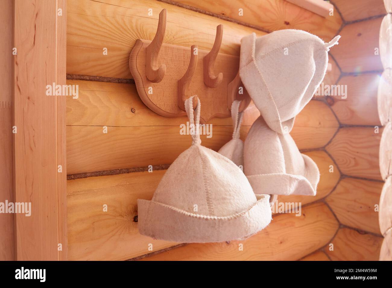 In der Sauna oder im Badehaus hängen Filzhüte für ein Dampfbad an einem Haken. Saunamützen. Stockfoto