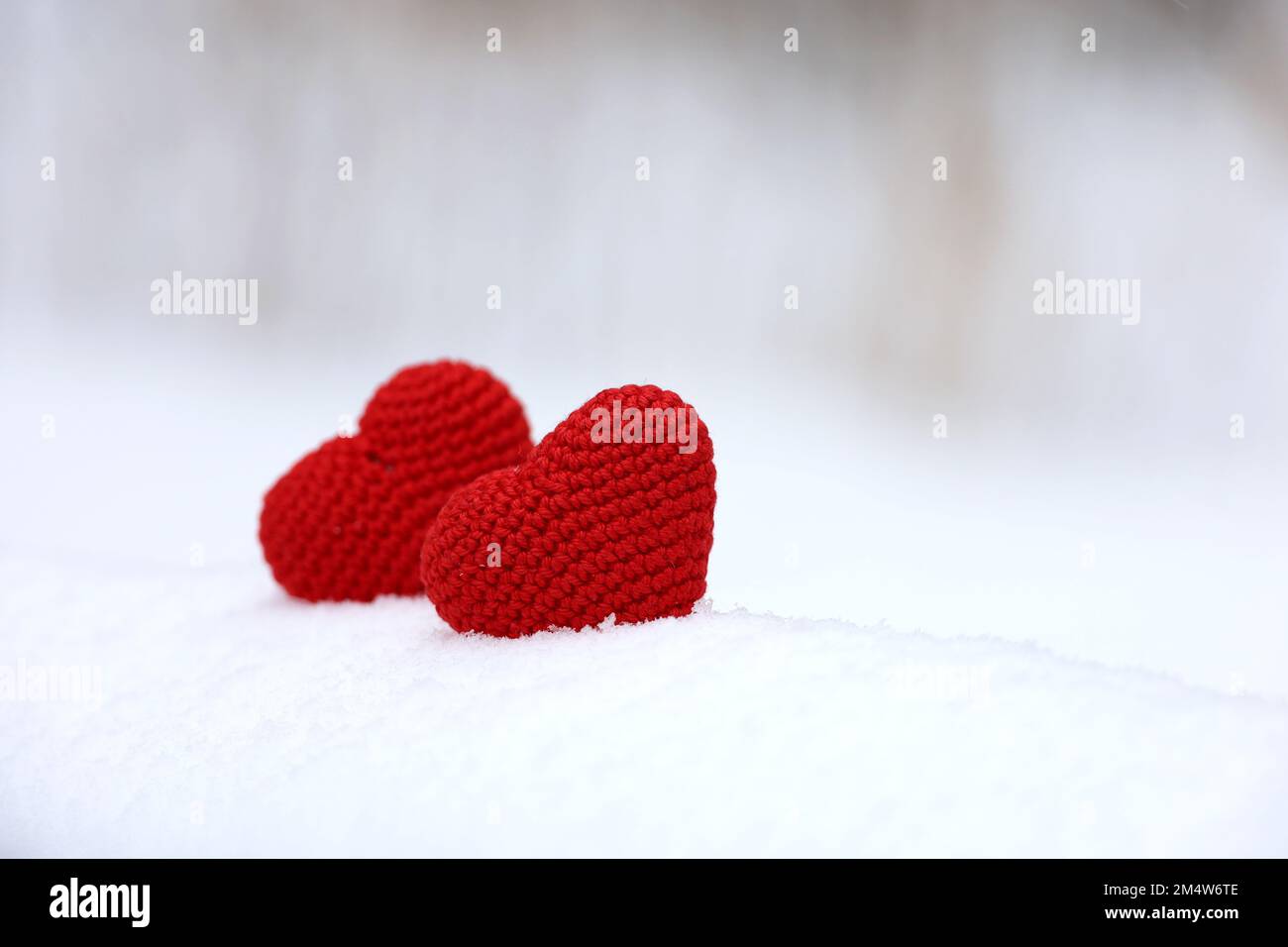 Zwei Liebesherzen im Schnee, Valentinskarte. Hintergrund für romantische Veranstaltungen, Weihnachtsfeiern oder Winterwetter Stockfoto