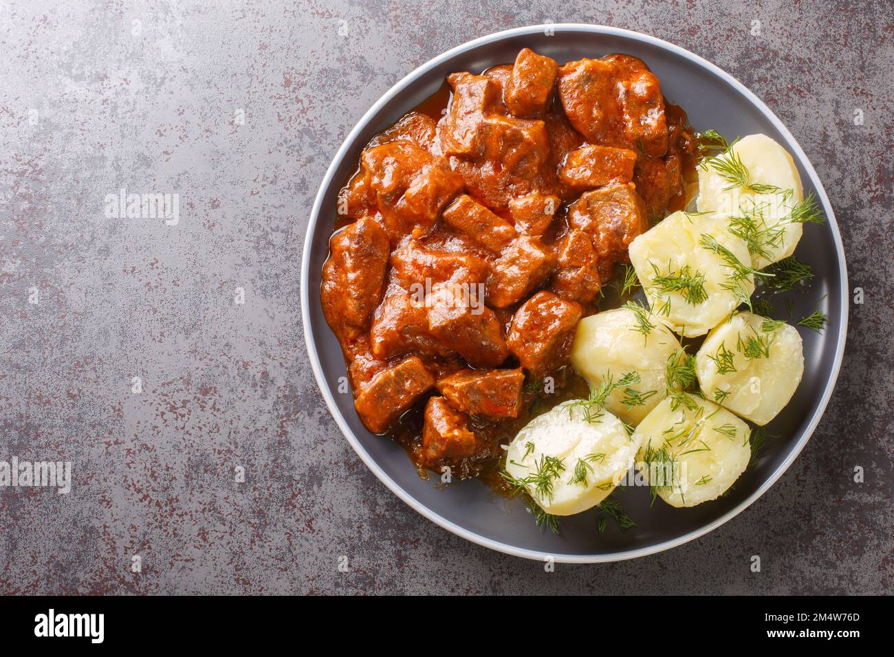 Wiener Rindergulasch mit dicker Sauce, serviert mit gekochten ...