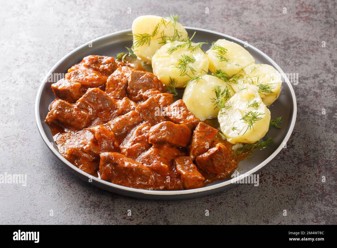 Wiener Rindergulasch mit dicker Sauce, serviert mit gekochten ...