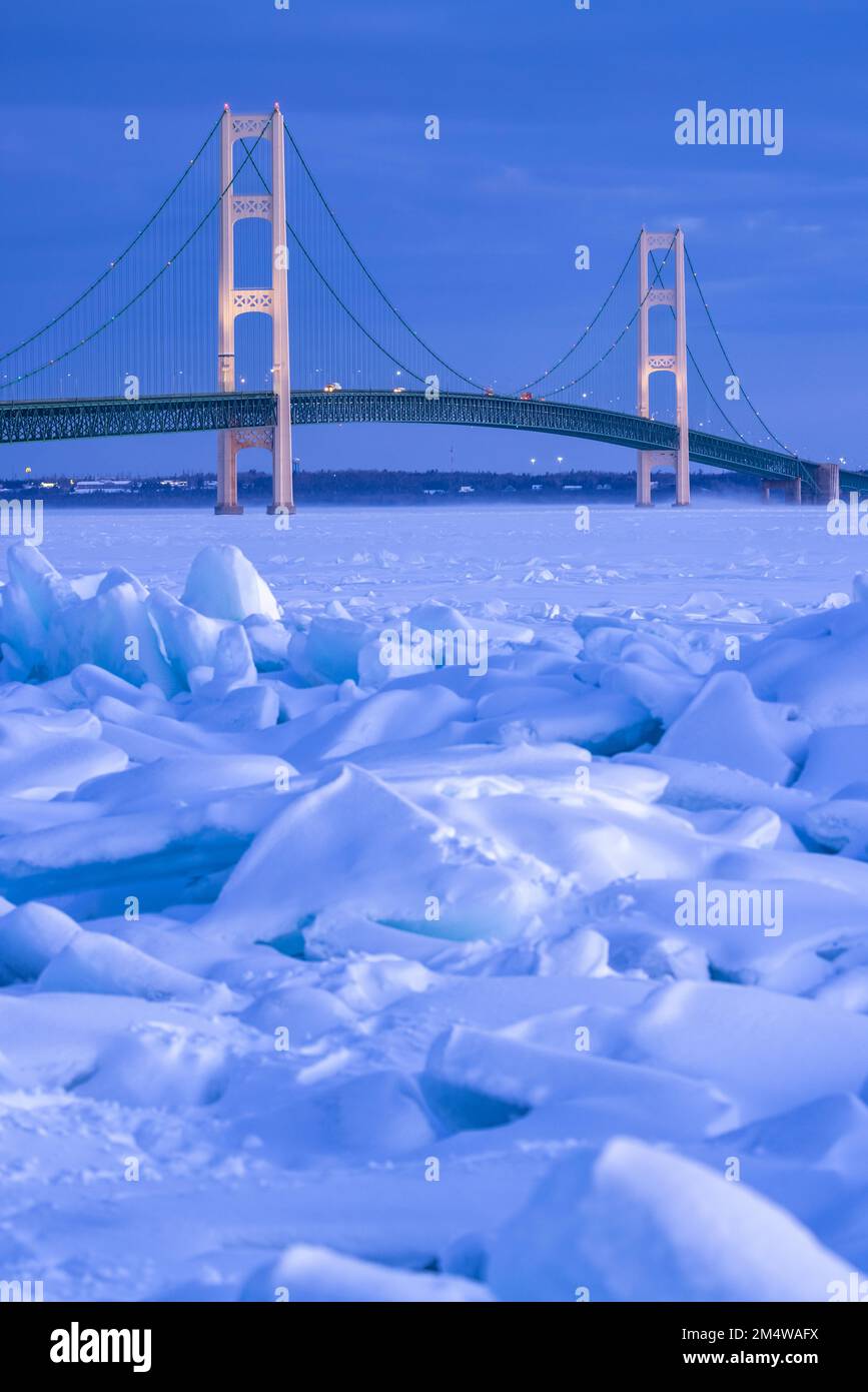 Blaues Eis stapelt sich entlang der Straße von Mackinac vor der Mackinac Bridge bei extremen Winterwetter. Stockfoto