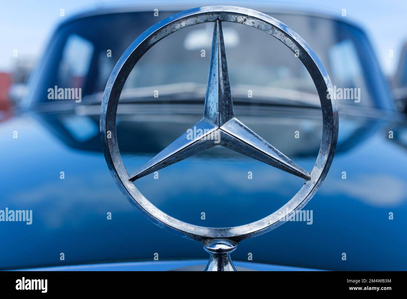Mercedes-Benz-Emblem auf der Motorhaube eines blauen Autos Stockfoto