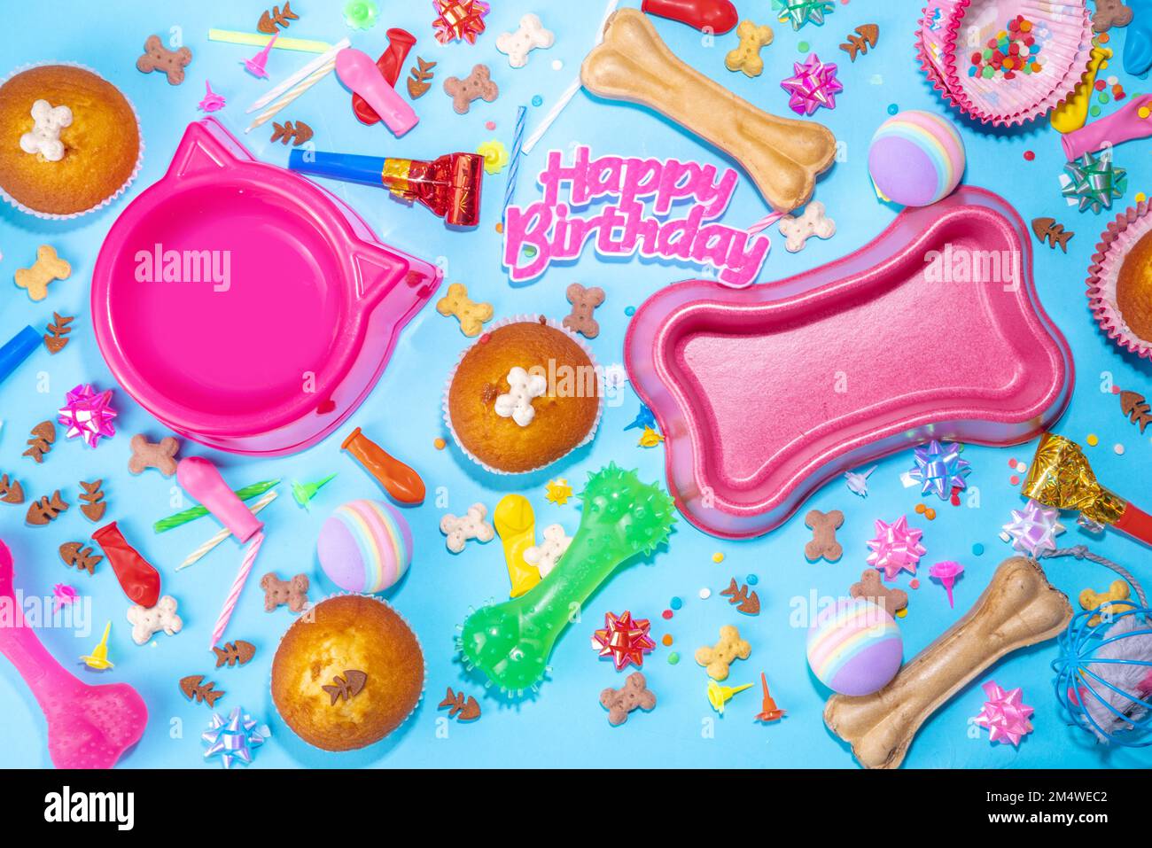 PET Happy Birthday Hintergrund mit Set Hund und Katze Snack, Futter und Spielzeug, Knochen und Katze geformte Schale, Geburtstag Cupcakes mit Happy Birthday Kerzen und ein Stockfoto