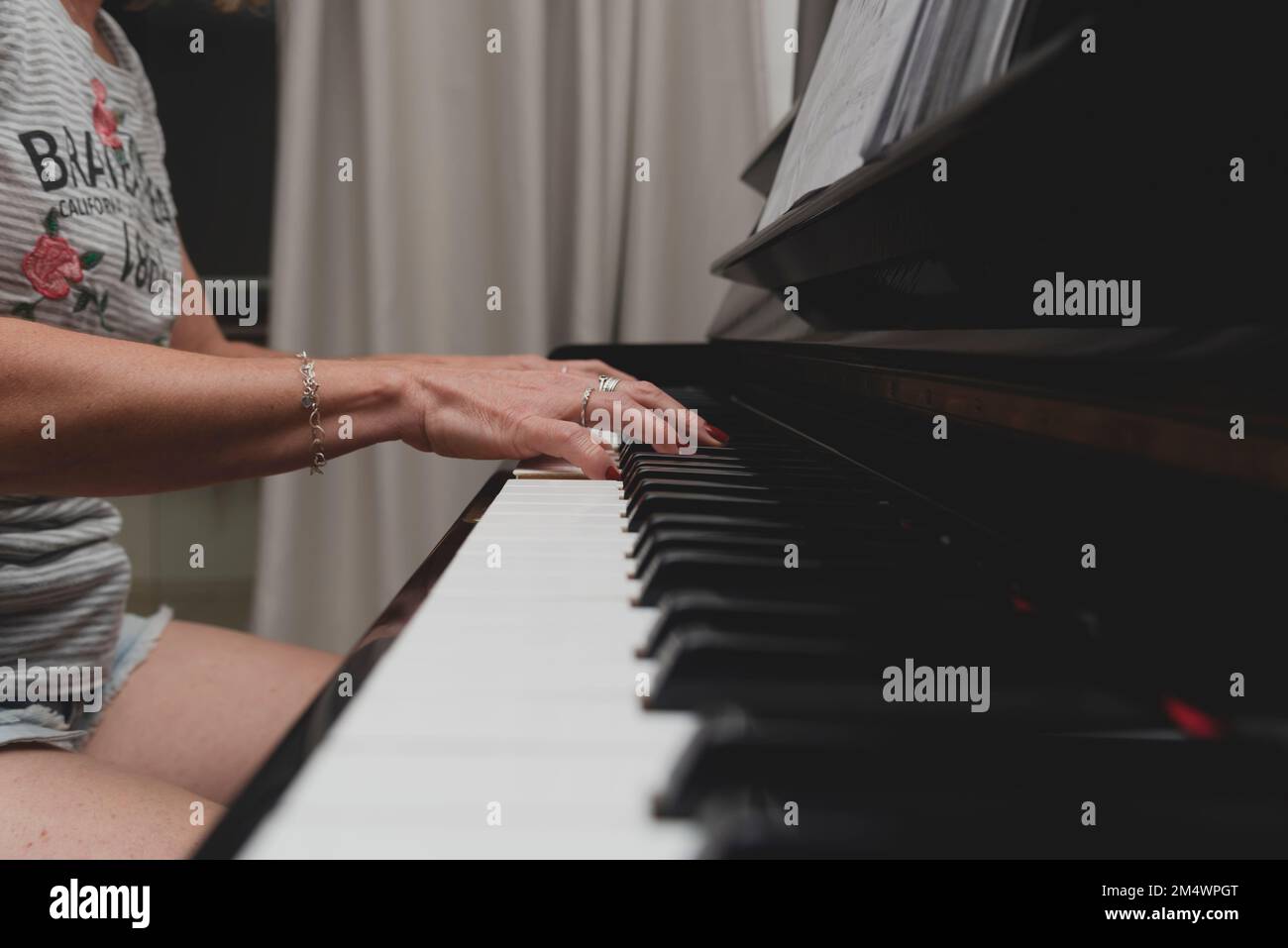 Schöne brasilianische Pianistin, die Klaviertasten berührt und Klavier spielt. Konzept Musikunterricht und Kunst. Entspannen und fröhlich. Stockfoto