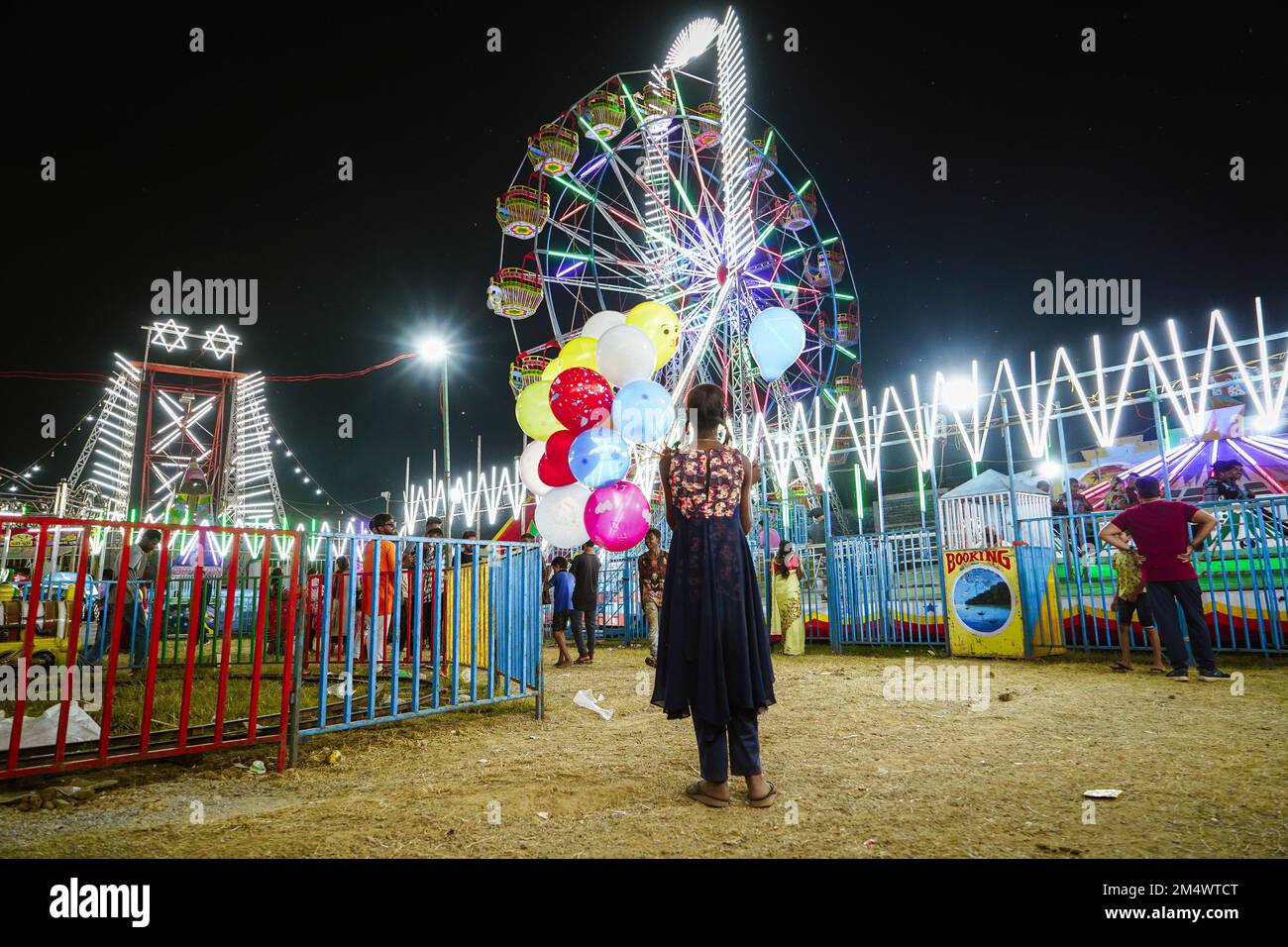10. november 2022, Raipur, chhattisgarh, ein kleines indisches Mädchen, das Ballons auf einem Jahrmarkt verkauft oder Riesenrad sieht und träumt, es zu genießen Stockfoto