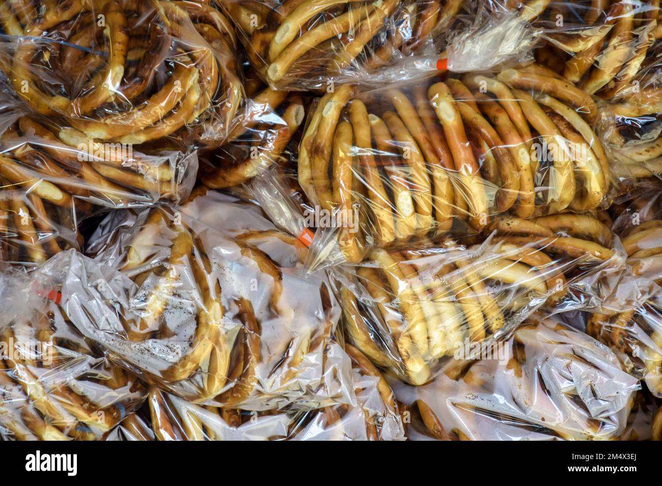 Bündel frisch gebackener Bagels mit Mohnsamen, die in Plastiktüten vernebelt wurden. Köstliche hausgemachte Bagels. Verkauf von frisch gebackenen Bagels auf der Messe. Ba Stockfoto