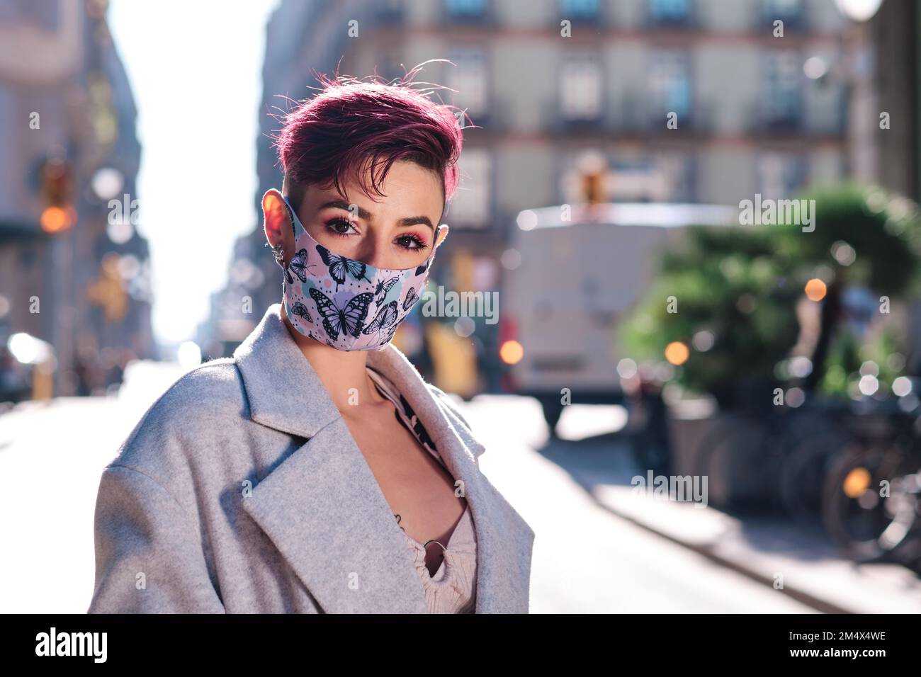 Stilvolle Frau mit Gesichtsmaske auf der Straße Stockfoto