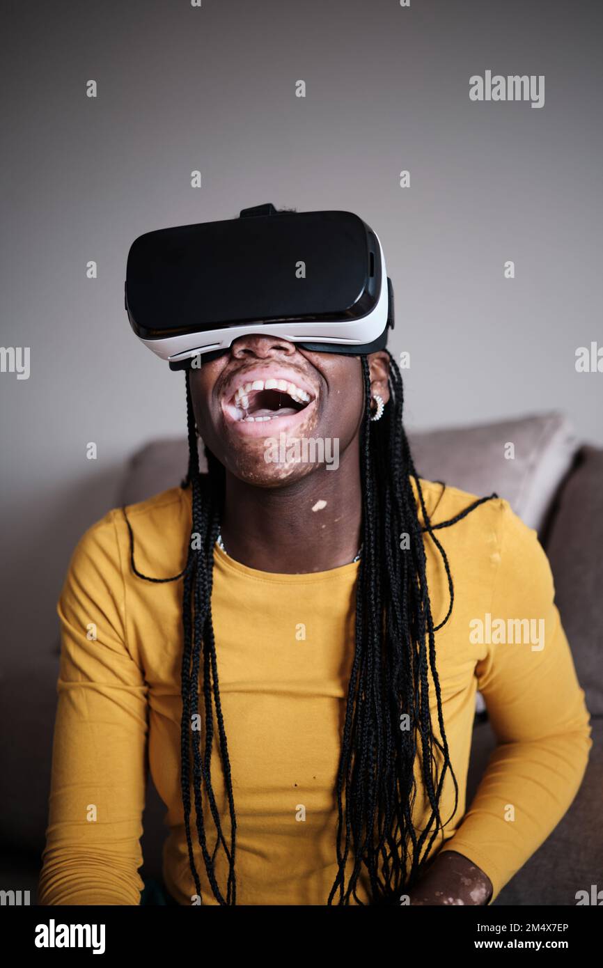 Glückliche afroamerikanische Frau mit weißer Pigmentierung auf der Haut im VR-Headset Stockfoto