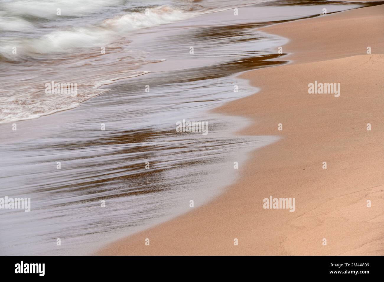 Sandstrand mit Kieselsteinen und Wellenreiten, Lake Superior Provincial Park - Gargantua, Ontario, Kanada Stockfoto