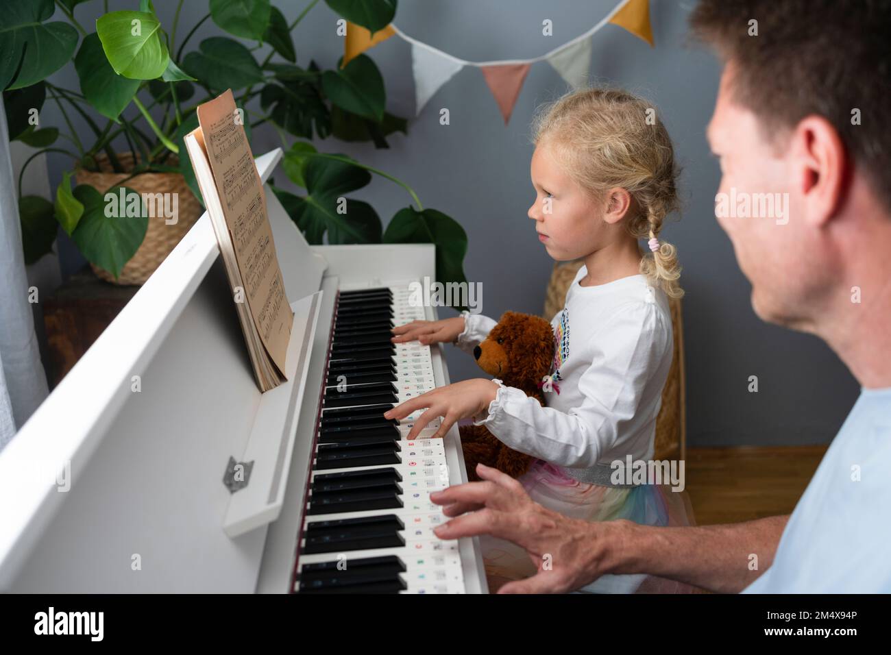 Ein Mädchen liest Musicals und spielt zu Hause Klavier Stockfoto