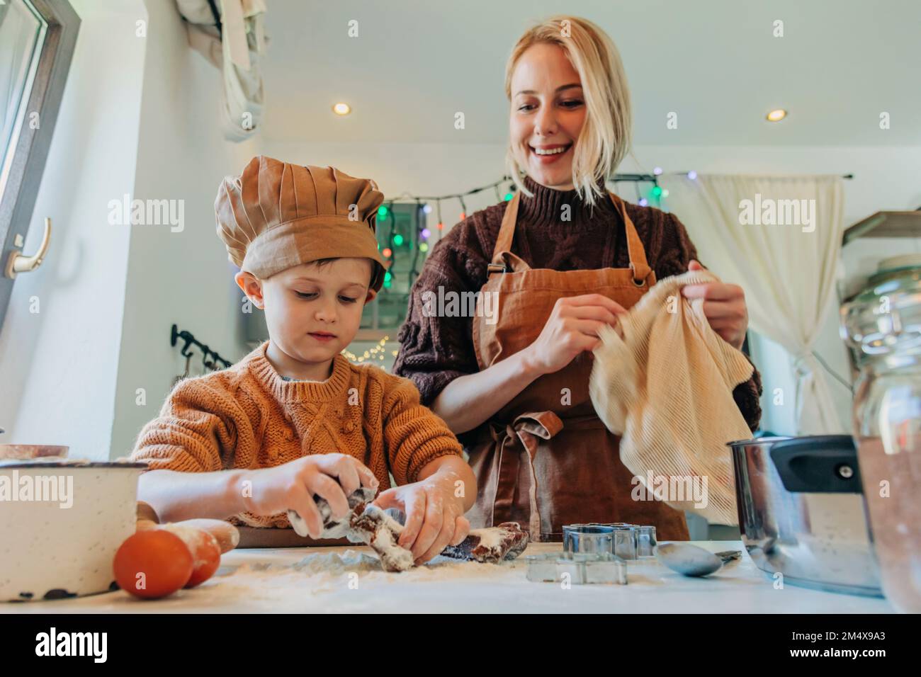 Glückliche Mutter und Sohn, die zu Hause Kekse zubereiten Stockfoto