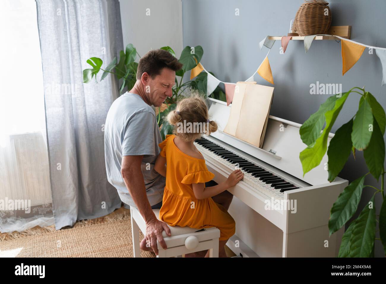 Vater unterrichtet Tochter Klavier zu Hause Stockfoto