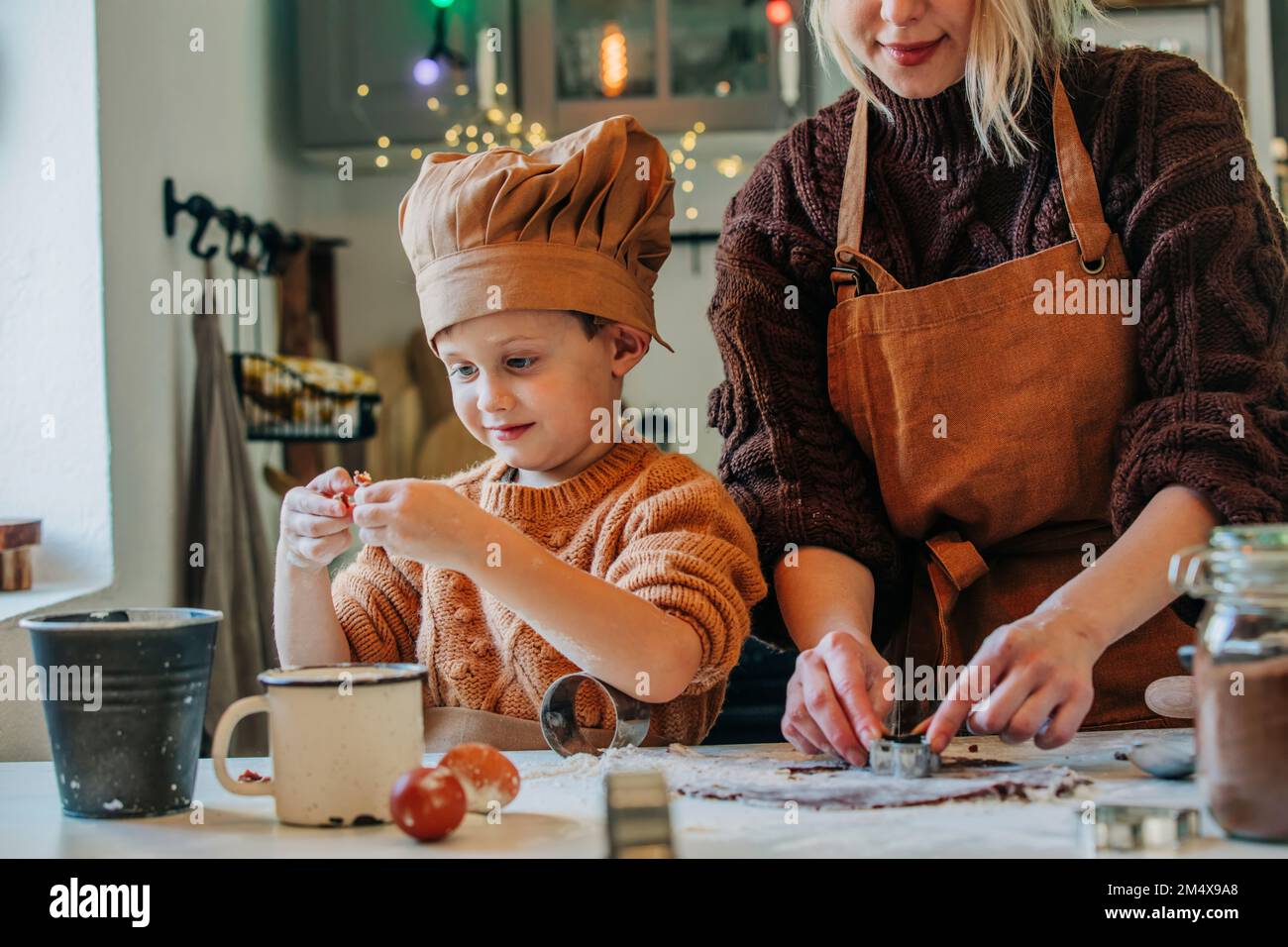 Lächelnde Mutter und Sohn, die zu Hause Kekse zubereiten Stockfoto
