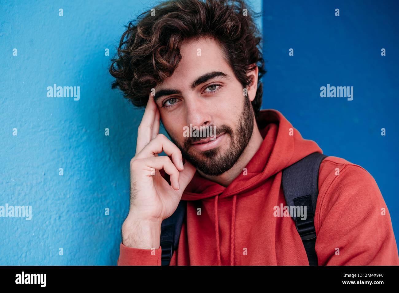 Junger Mann mit Bart an der blauen Wand Stockfoto