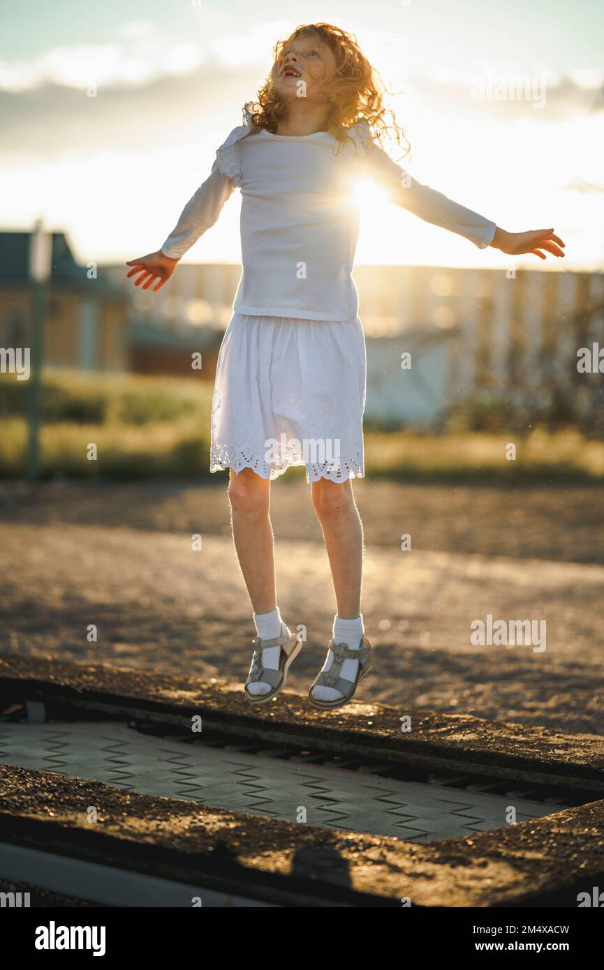 Glückliches Mädchen, das im Park auf Trampolin springt Stockfoto