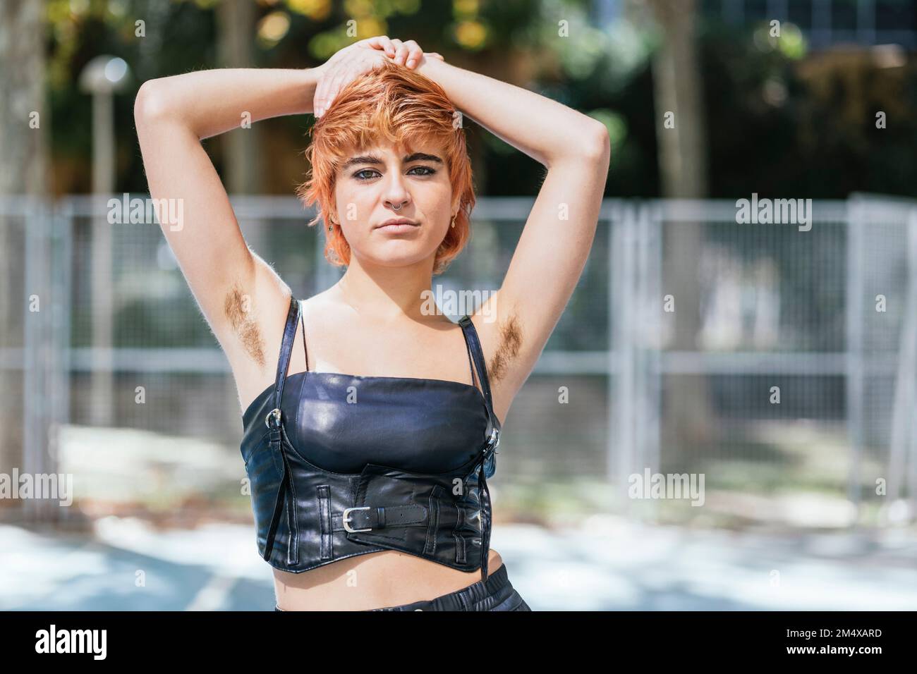 Selbstbewusste junge Frau, die Korsett trägt und Achselhaare zeigt Stockfoto