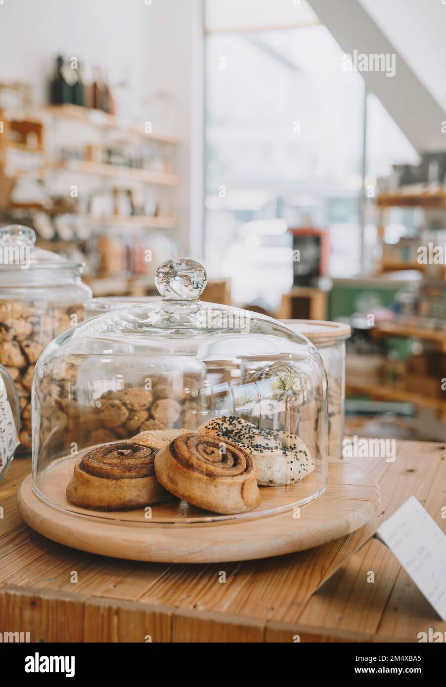 Zimtbrötchen unter dem Glasdeckel auf dem Tisch im Nullmülllager Stockfoto