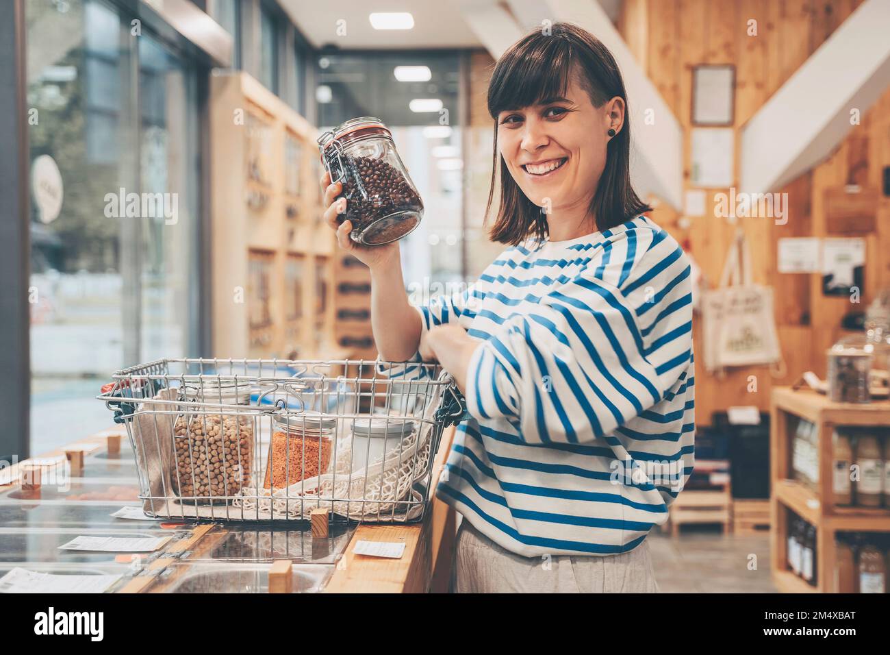 Lächelnder Gast mit Kidney Beans Dose an der Theke im 24-Stunden-Geschäft Stockfoto