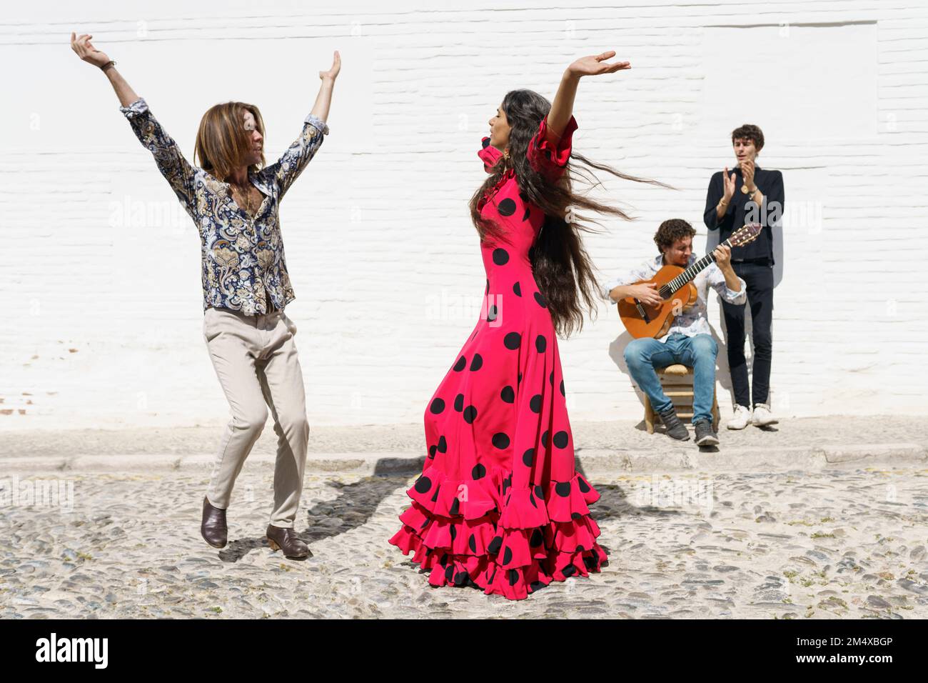 Flamenco-Tänzer treten an sonnigen Tagen mit Gitarrist auf Stockfoto