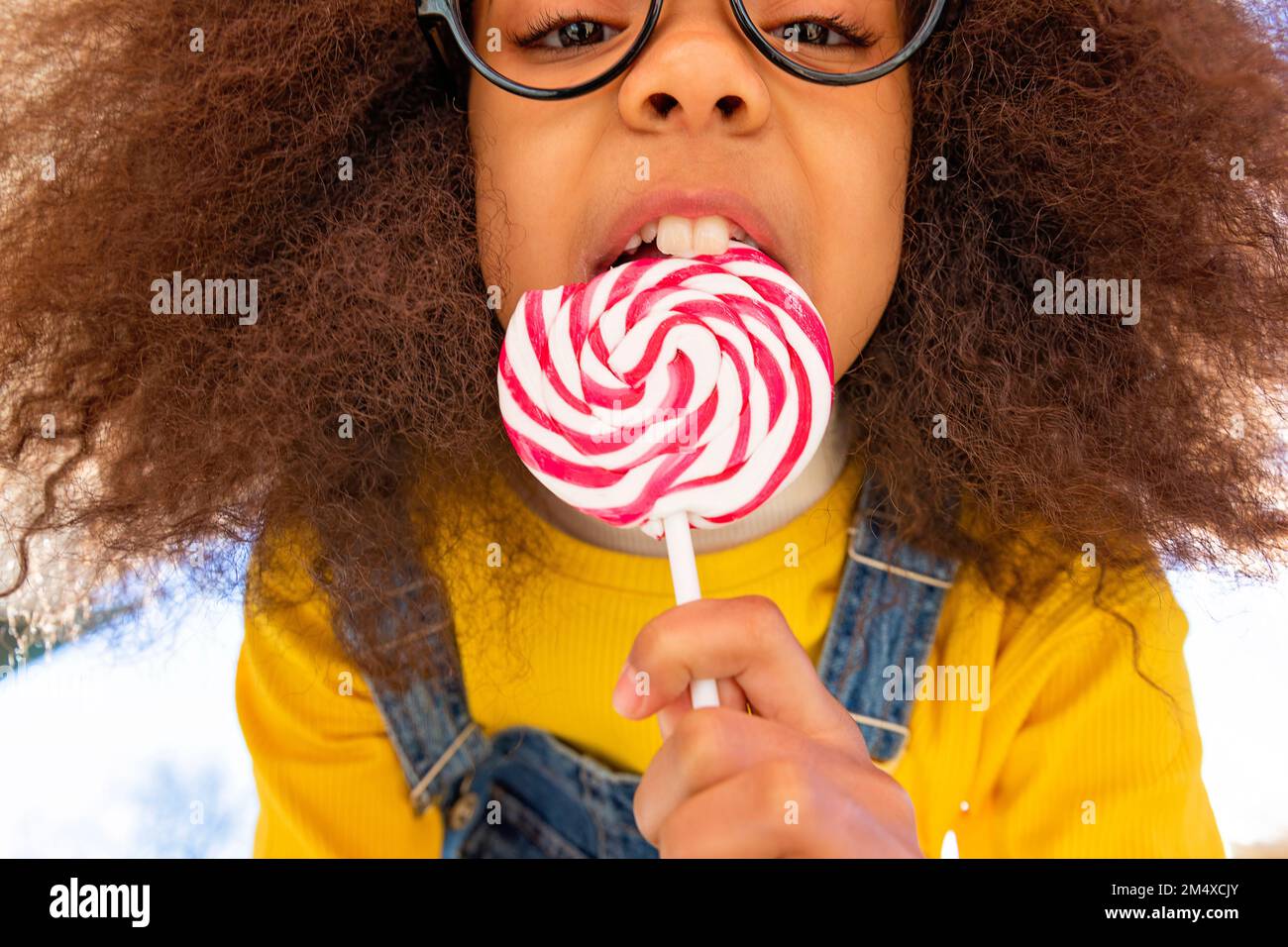 Ein Mädchen mit Backenzähnen isst Lutscher Stockfoto