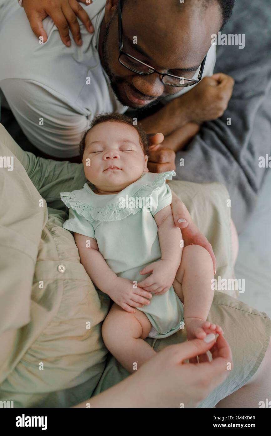Lächelnde Vater und Mutter mit einem kleinen Mädchen zu Hause Stockfoto