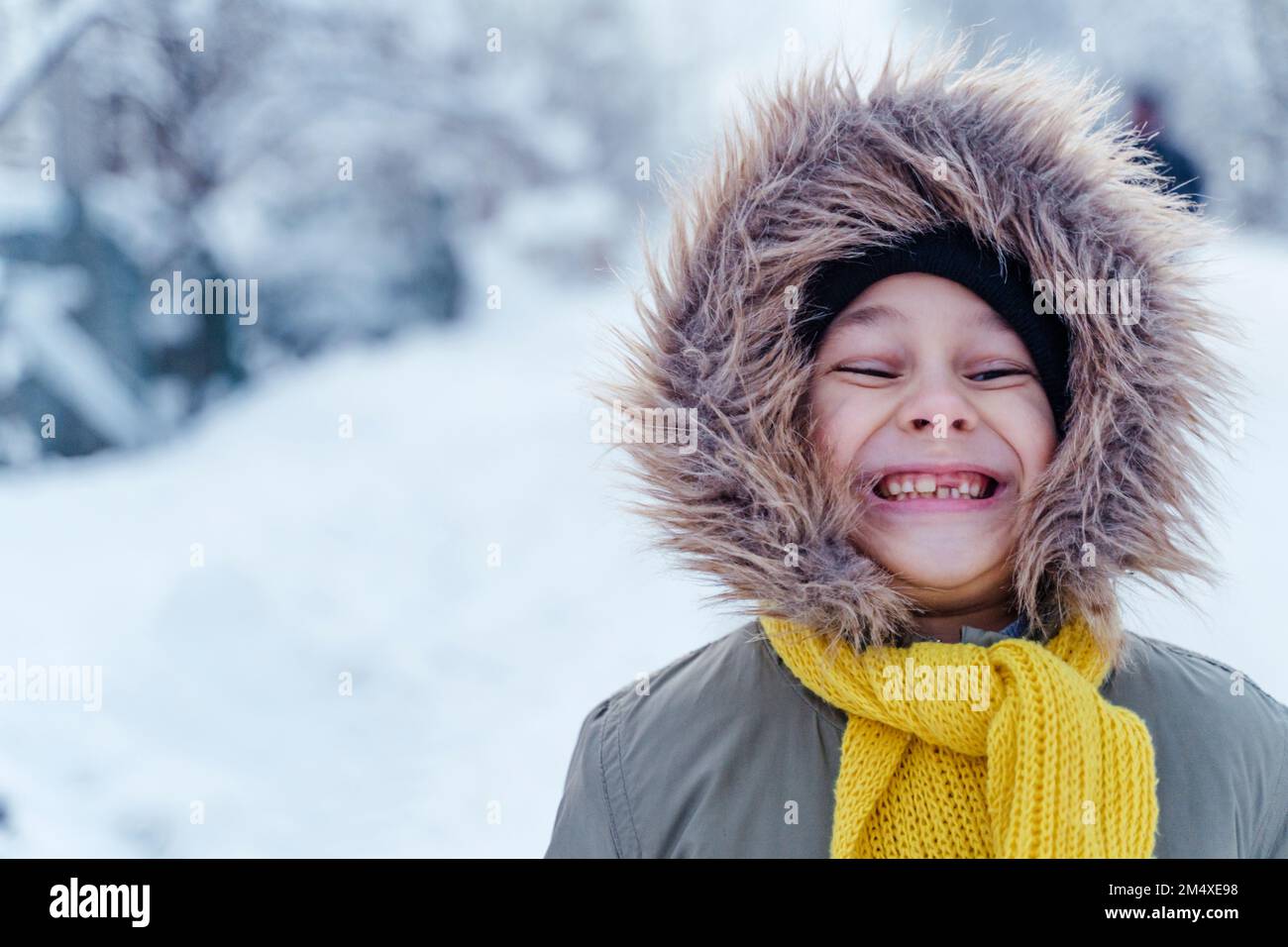 Glücklicher Junge, der im Winter warme Kleidung trägt Stockfoto