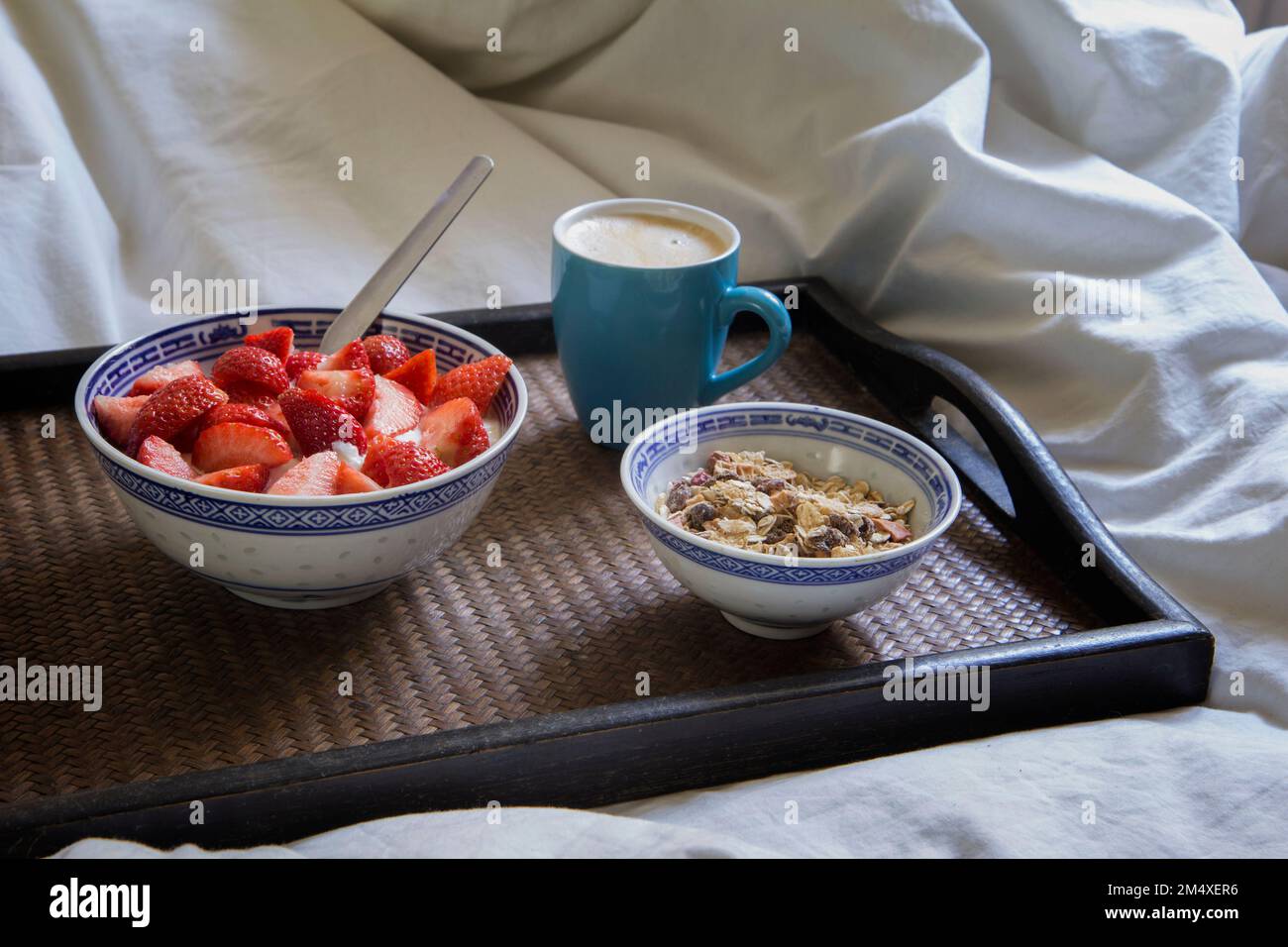 Tablett mit einer Tasse Kaffee, Müsli und Joghurt mit Erdbeeren Stockfoto