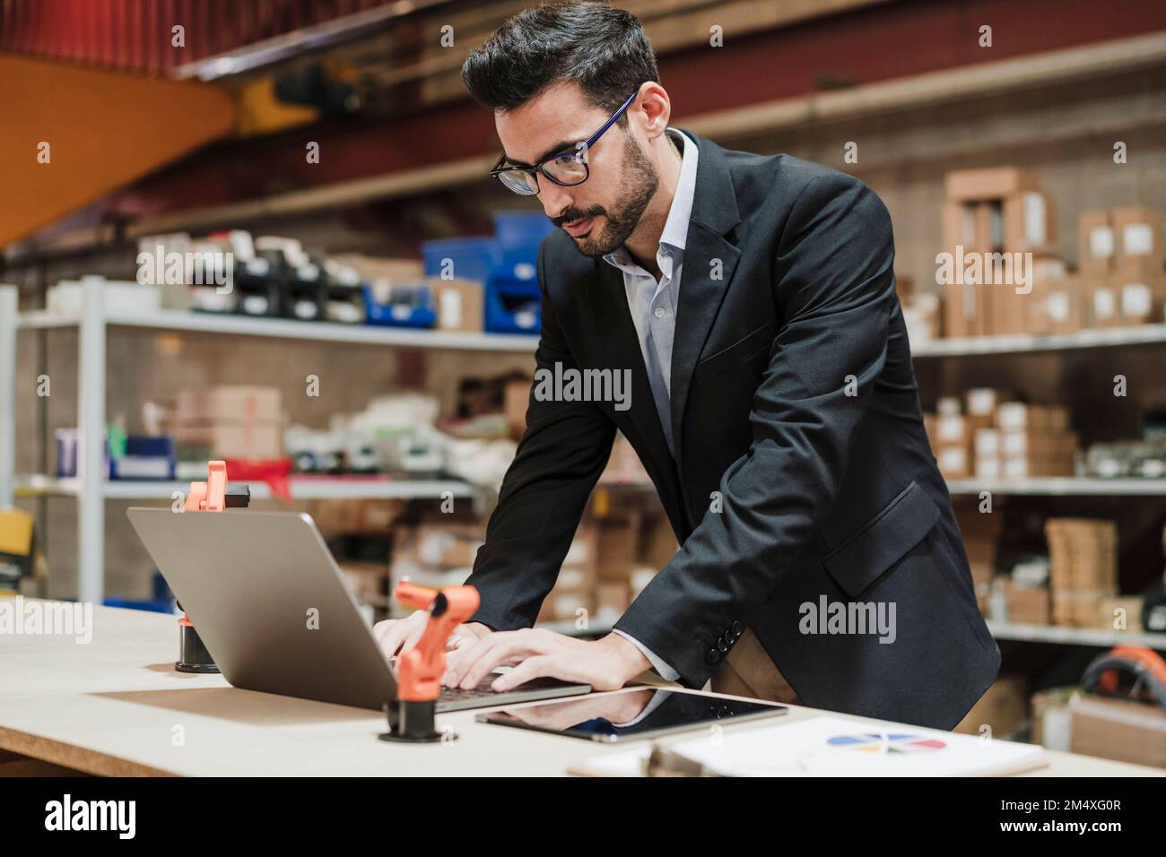 Geschäftsmann, der in der Industrie mit einem Notebook arbeitet Stockfoto