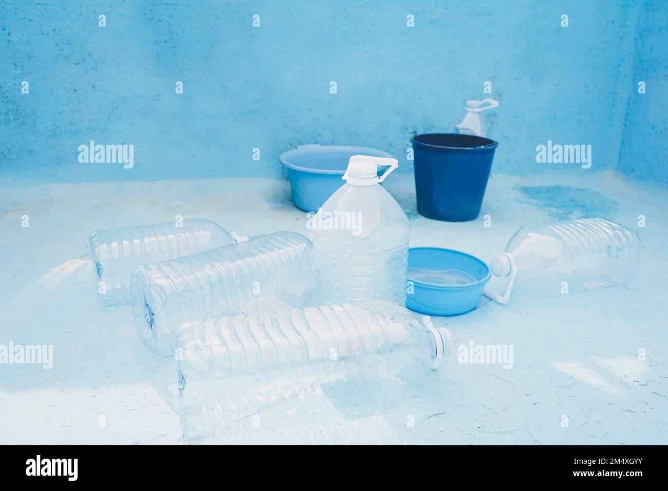 Plastikflaschen und -Eimer im leeren Pool Stockfoto