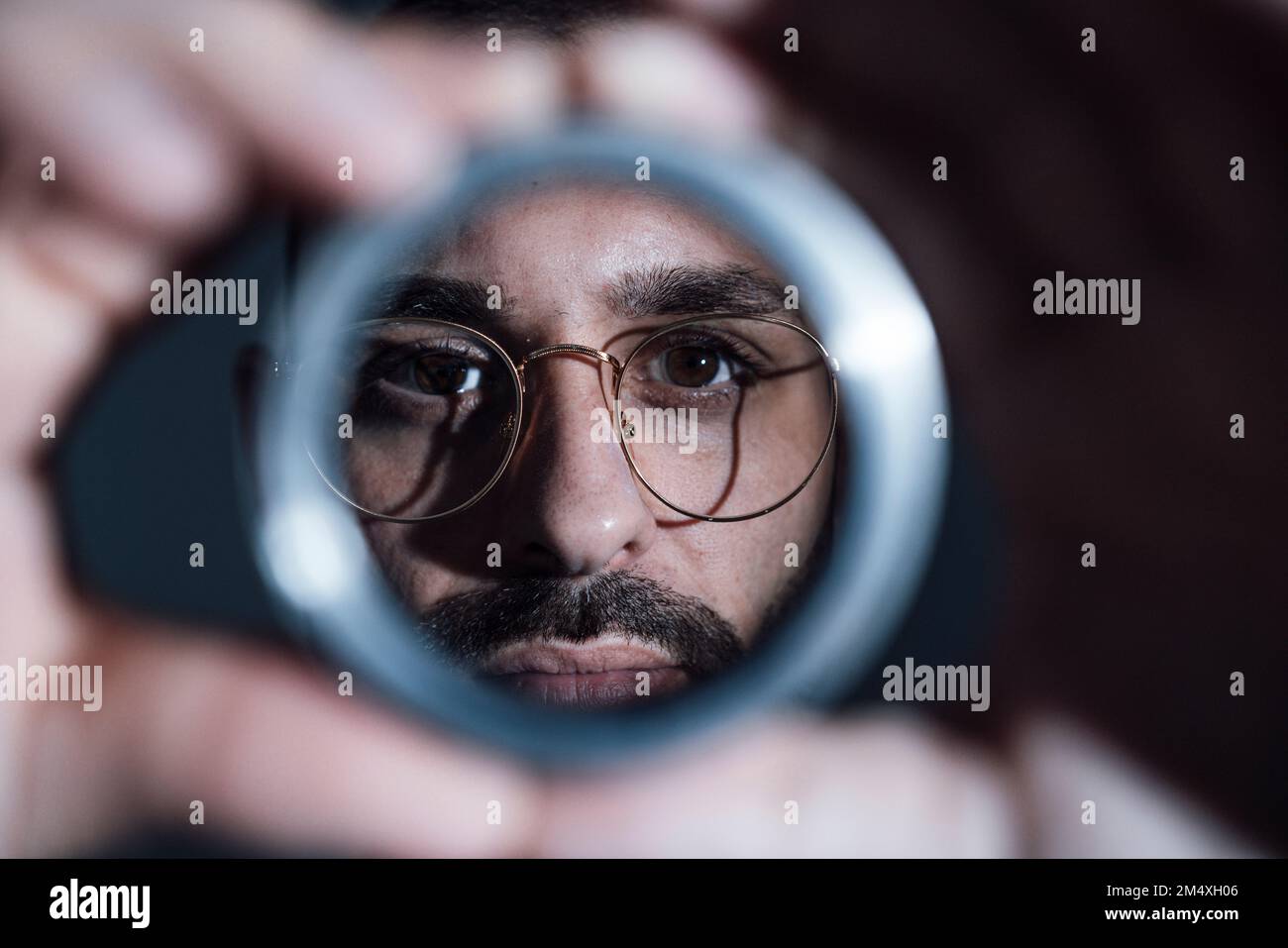 Ein Geschäftsmann, der im Büro ein Objekt durchsucht Stockfoto