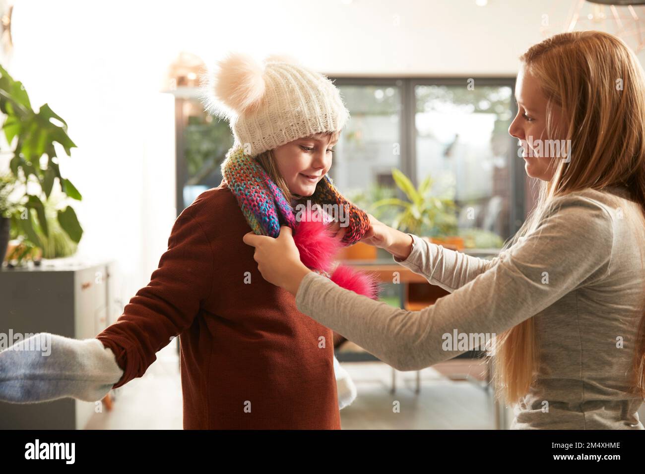 Lächelndes Mädchen, das sich zu Hause als Schwester verkleidet Stockfoto