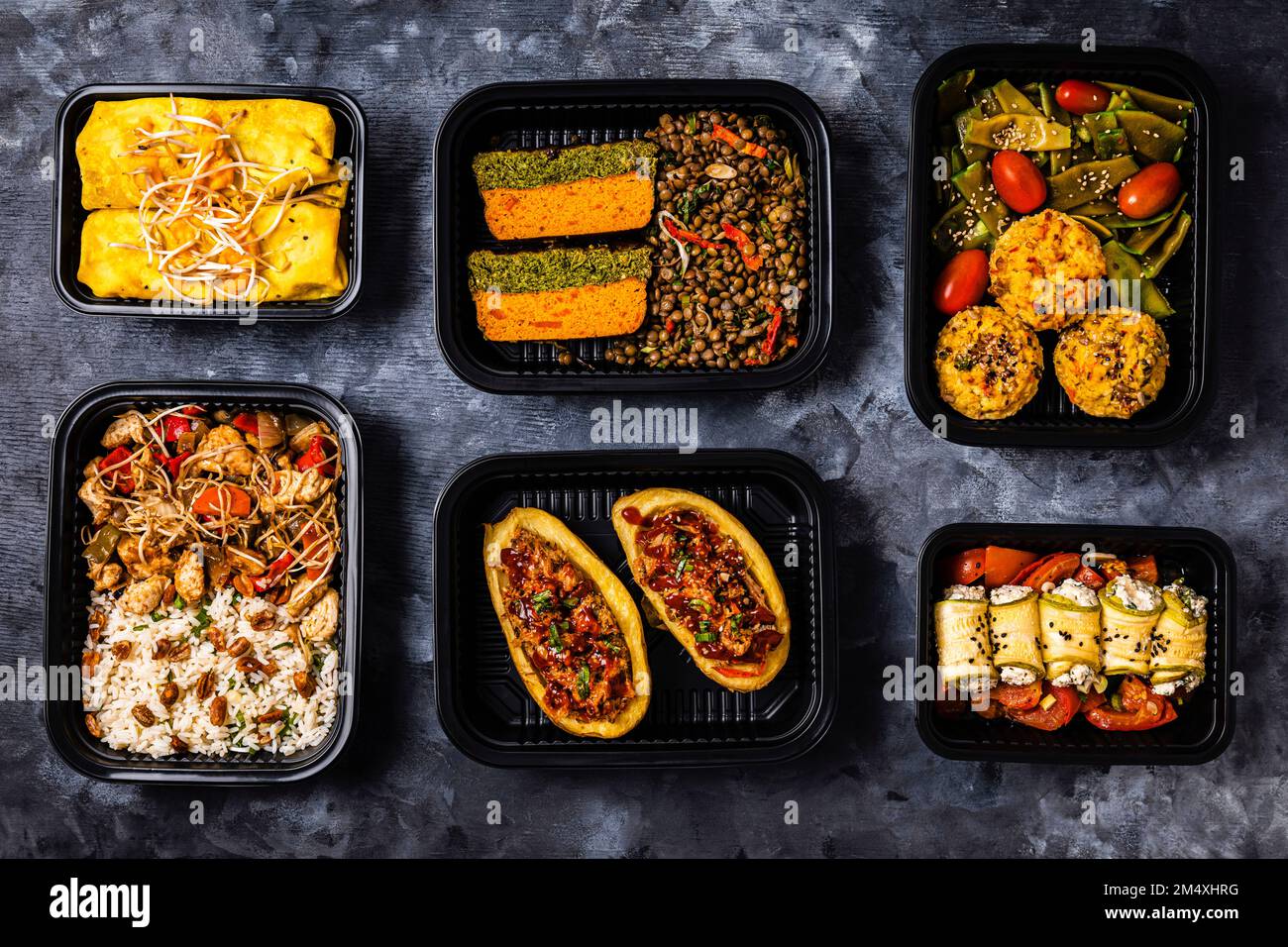 Studioaufnahme mit einer Vielzahl von Speisen zum Mitnehmen, einschließlich Chop Suey, gefüllte Kartoffeln, Fajitas, Reismuffins, Ricotta Brötchen, Verschiedene Salate und Terrine Stockfoto