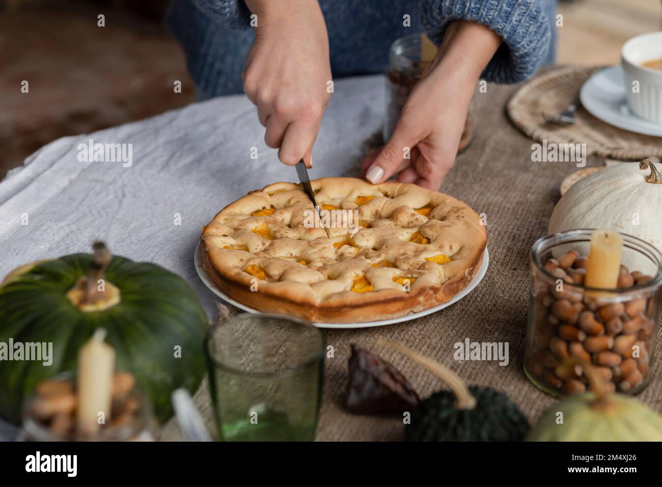 Hände einer Frau, die hausgemachten Kürbiskuchen schneidet Stockfoto