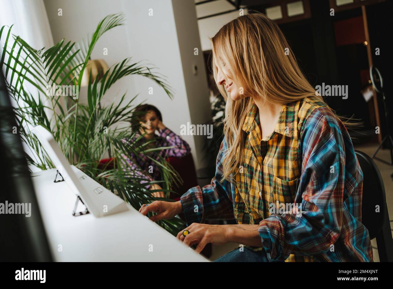 Lächelnder Pianist, der im Studio Klavier spielt Stockfoto