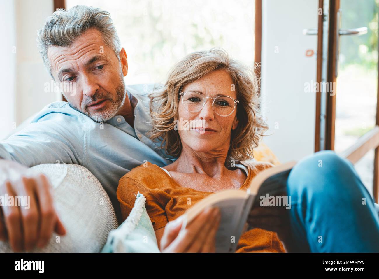 Reife Frau und Mann lesen zu Hause zusammen Buch Stockfoto