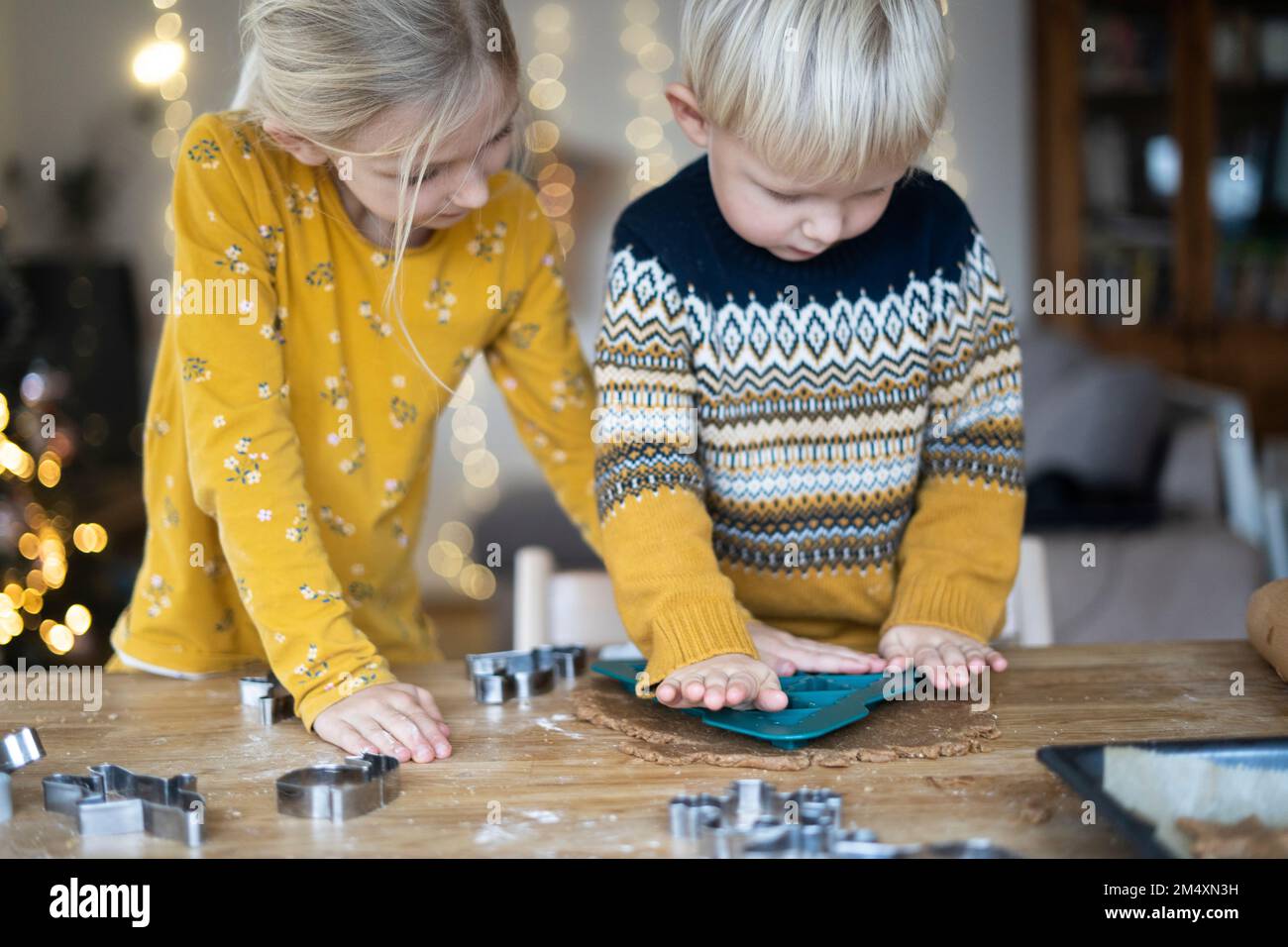 Junge Formen auf Teig von Schwester zu Hause Stockfoto