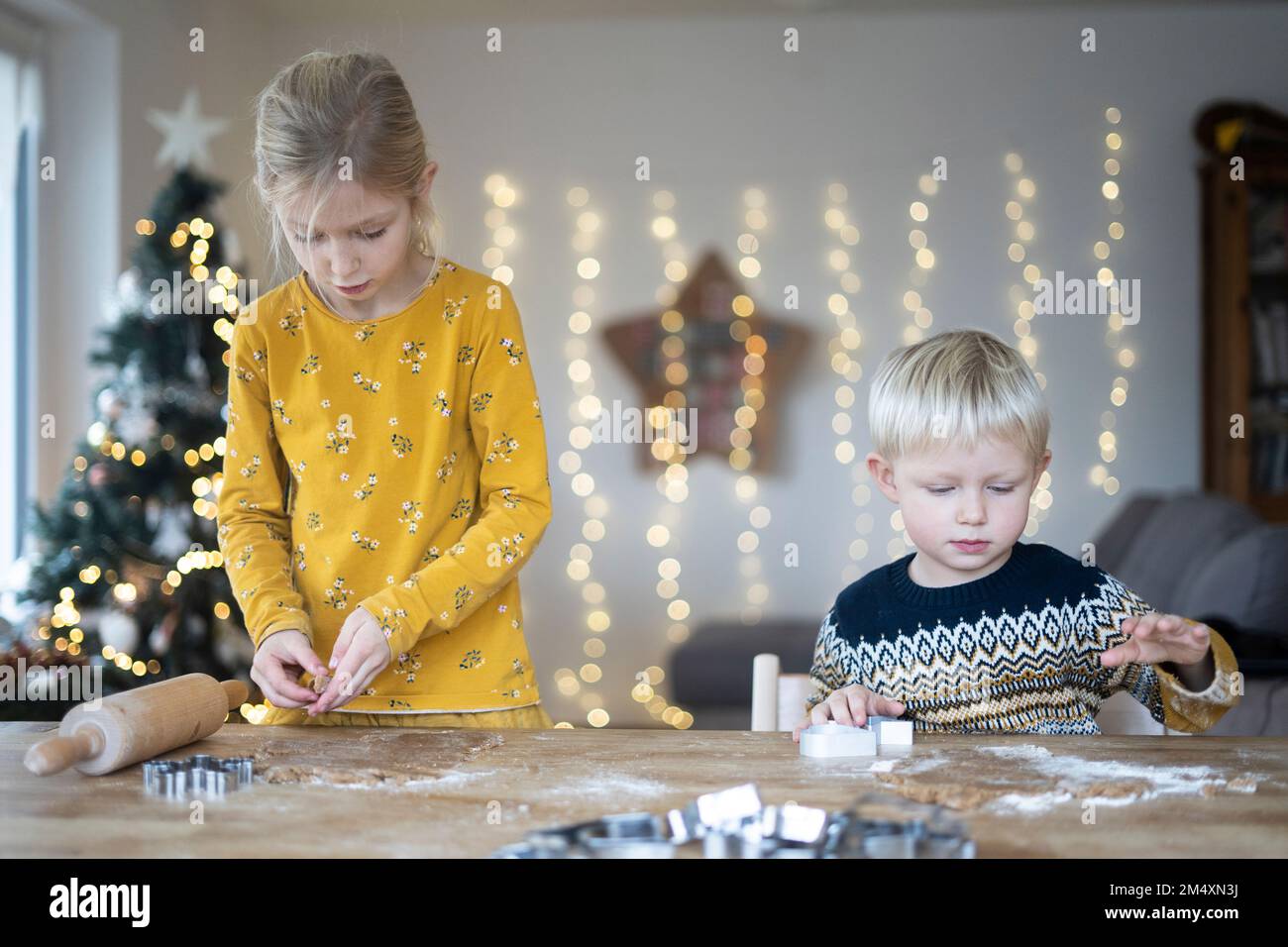 Bruder und Schwester, die Weihnachten am Tisch Kekse zubereiten Stockfoto