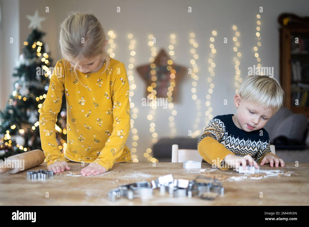 Geschwister, die Weihnachten am Tisch Kekse zubereiten Stockfoto