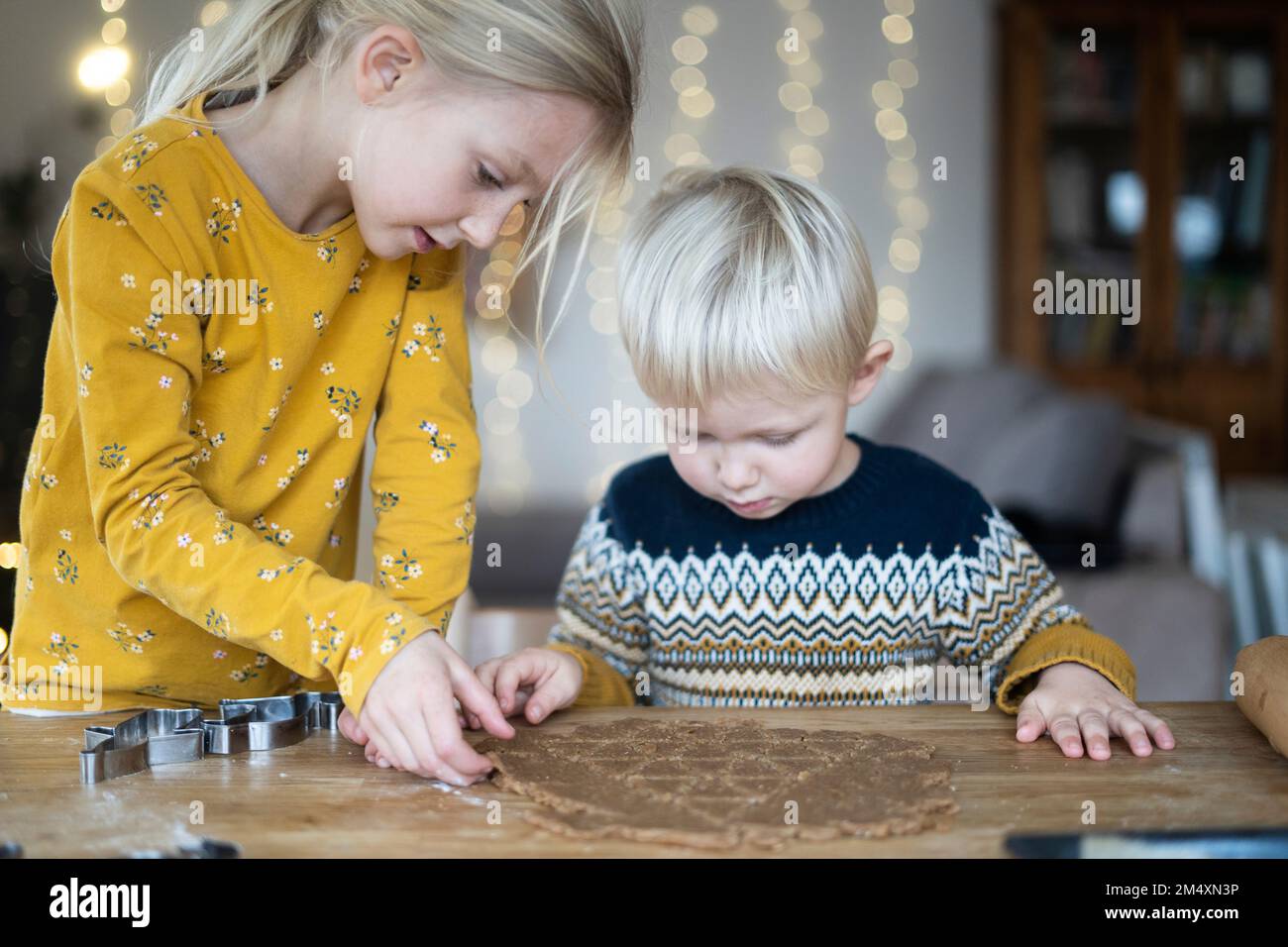 Blonder Bruder und blonde Schwester bereiten zu Hause Kekse zu Stockfoto